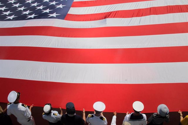 Archivo - 30 May 2022, US, New York: Sailors hold a US flag at the Memorial Day ceremony at the Intrepid Sea, Air, and Space Museum. Photo: Bruce Cotler/ZUMA Press Wire/dpa