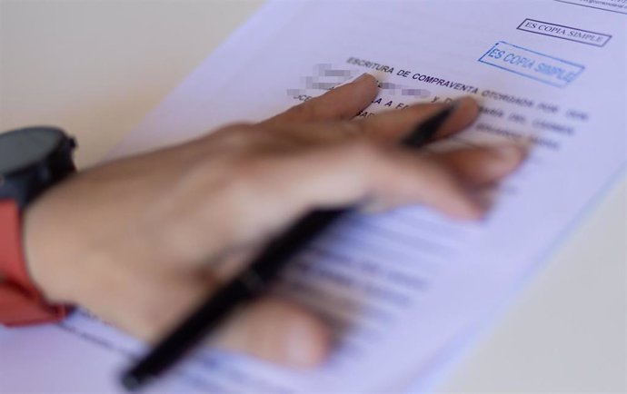 Archivo - Una mujer con un bolígrafo, señala una escritura de compraventa de una hipoteca, a 30 de mayo de 2022, en Madrid (España).