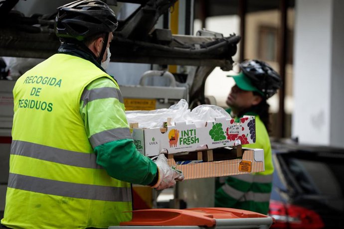 Archivo - Un operario de recogida de residuos protegidos con mascarilla.