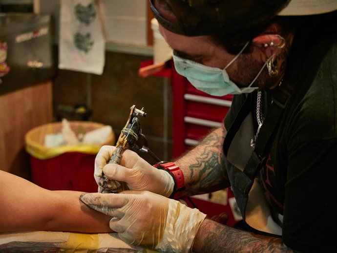 Archivo - Un tatuador trabajando, en una imagen de archivo.