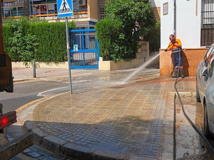 Operario de Lipasam baldeando una calle. 