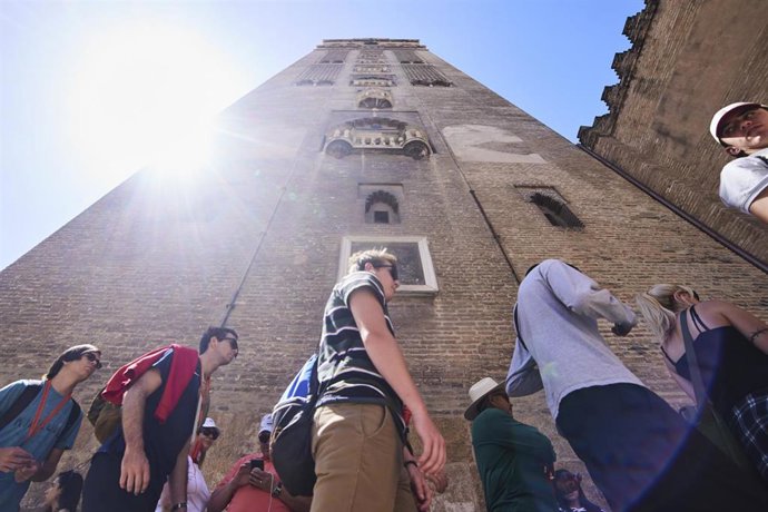 Turistas hacen cola bajo la Giralda para entrar a la visita de la Catedral.