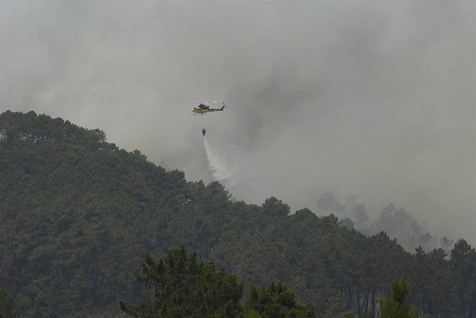 Un helicóptero apaga un incendio forestal en Galicia. Foto de archivo.