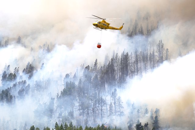 Un helicóptero contra incendios descarga agua sobre un incendio forestal en Tenerife Norte, a 23 de julio de 2022, en Tenerife, Santa Cruz de Tenerife