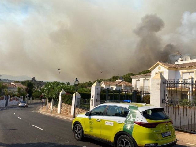 Un coche del 112 Emergencias Andalucía junto al incendio forestal que está activo en Alhaurín el Grande (Málaga), a 16 de julio de 2022