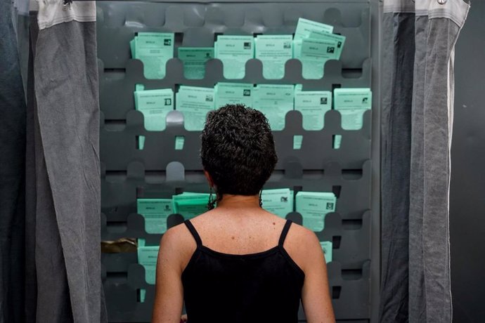 Una mujer observa las papeletas para ejercer su derecho al voto durante el día de las elecciones a la presidencia de la Junta de Andalucía  a 19 de junio de 2022 en Sevilla (Andalucía, España) (Foto de archivo).