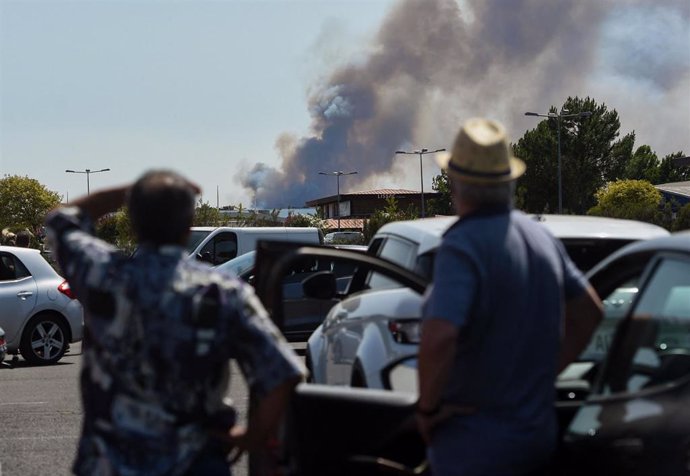 16 July 2022, France, La Teste-De-Buch: People observe a fire from La Teste-de-Buch. The fire in Teste-de-Buch has intensified and threatened campsites, the local authority said in a statement. More than 14,000 people in the area have already had to lea