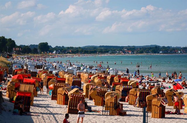 13 July 2022, Schleswig-Holstein, Scharbeutz: People enjoy the summer weather on the beach of the Baltic Sea near Scharbeutz. Photo: Christian Charisius/dpa