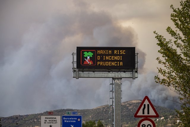 Humo junto a la pantalla de tráfico, en la carretera, que anuncia un incendio forestal, a 17 de julio de 2022, en Pont de Vilomara, Barcelona, Cataluña, (España). 