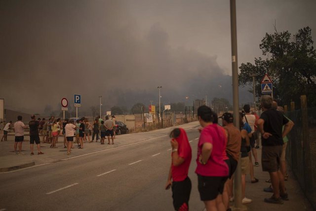 Varias personas observan el denso humo provocado por el incendio de Pont de Vilomara