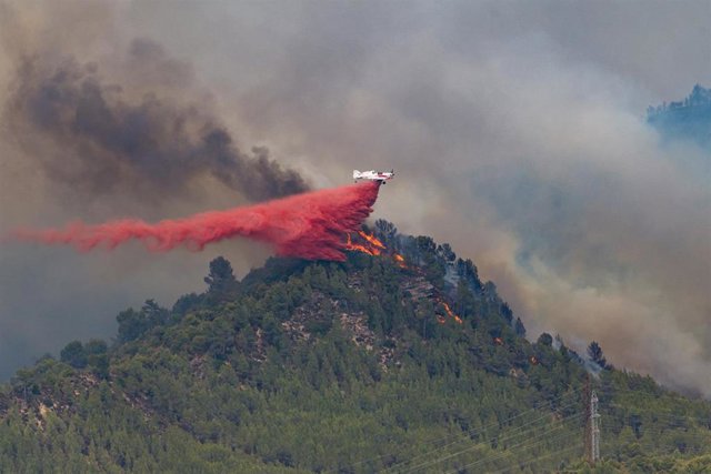 Un hidroavión descarga retardante sobre las llamas de un incendio forestal, a 17 de julio de 2022, en Castellgalí, Barcelona