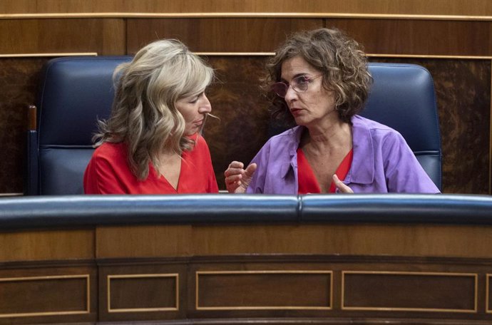 La vicepresidenta segunda del Gobierno, Yolanda Díaz (i), conversa con la ministra de Hacienda, María Jesús Montero, durante una sesión extraordinario en el Congreso de los Diputados, a 13 de julio de 2022, en Madrid (España).