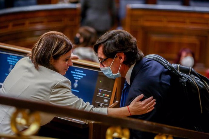 Archivo - La vicesecretaria General del PSOE, Adriana Lastra, tiende el brazo al primer secretario del PSC, Salvador Illa, en el Congreso de los Diputados.