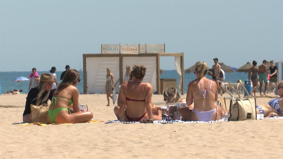 Turistas y vecinos en Valencia combaten la ola de calor con un baño en la playa