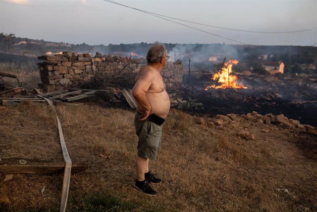 Un vecino observa las llamas del incendio de Losacio, a 17 de julio de 2022, en Losacio, Zamora, Castilla y León (España). Un brigadista de una autobomba que trabajaba en la extinción del incendio ha fallecido víctima del rápido avance de las llamas en la