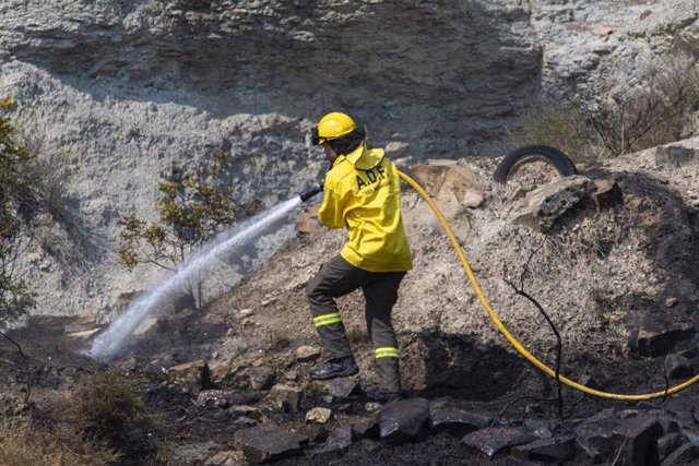 Un bombero echa agua en la zona vegetal afectada por un nuevo incendio cerca del antiguo vertedero del Pont de Vilomara, a 18 de julio de 2022, Barcelona, Catalunya (España). 