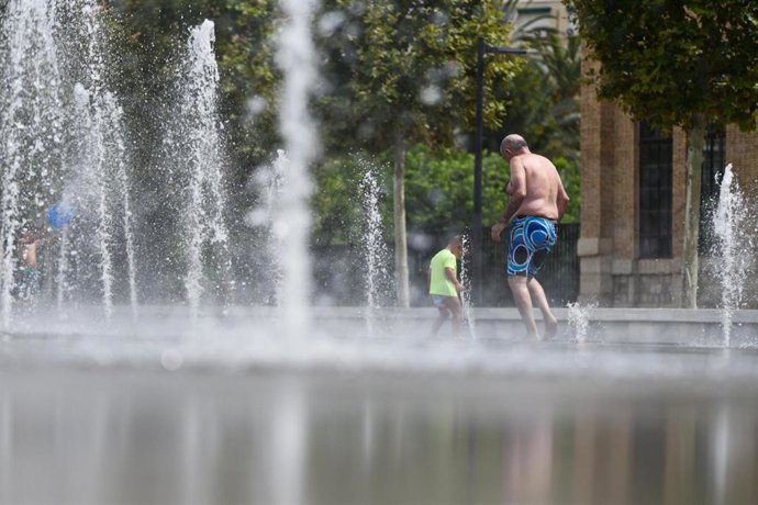 Archivo - Dos personas se refrescan en una fuente del Parc Central