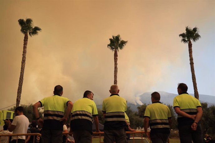 Efectivos desplegados en el incendio de la Sierra de Mijas iniciado el 15 de julio observan la humareda. En Alhaurín el Grande.