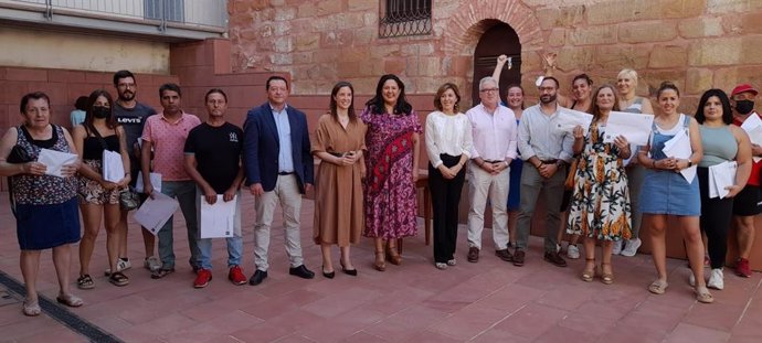 Cristina Casanueva y Dolores Amo (centro), junto a otras autoridades y los adjudicatarios de las viviendas.