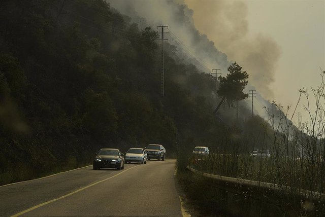 Varios coches desalojan la zona debido al incendio en el municipi en O Barco de Valdeorras, Ourense.