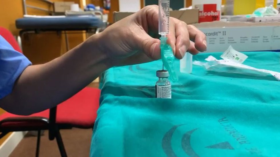 Archivo - Un profesional sanitario con una vacuna. Imagen de archivo.