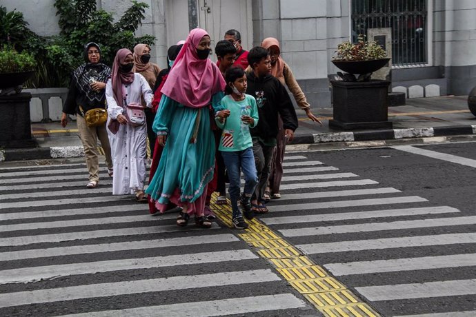 Mujeres y niños cruzando una calle en Indonesia