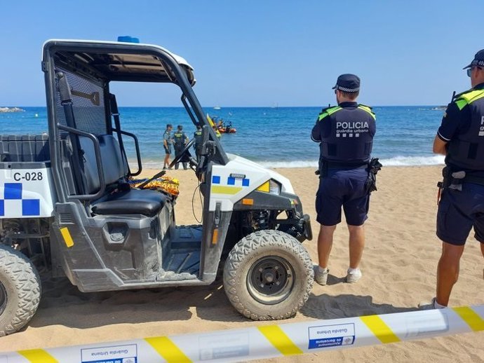 Cuerpos policiales controlan la zona de la playa de Somorrostro de Barcelona, desalojada por precaución al detectarse un objeto metálico en el fondo del mar