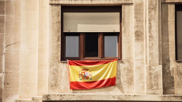 Imagen de recurso de una bandera de España colgada en un balcón