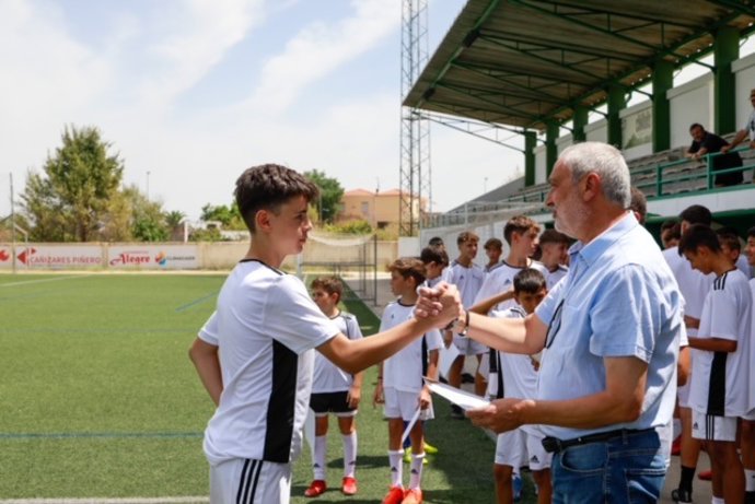 El presidente de la Diputación de Cáceres, Carlos Carlos, entrega un diploma a uno de los niños que ha participado en el Campus Experience del Real Madrid en Navalmoral de la Mata