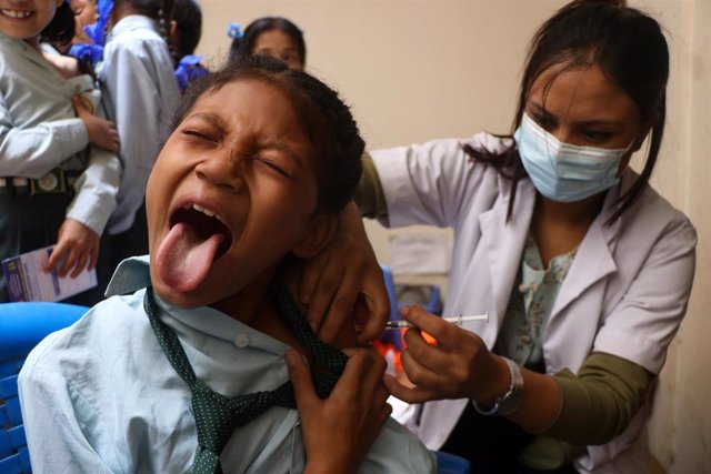 23 June 2022, Nepal, Kathmandu: A girl receives the Covid-19 vaccine at a school where the Nepalese Government began vaccinating children aged 5-12.