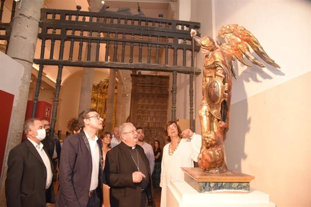 El director del museo, el obispo y la presidente de la Diputación ante la imagen de San Miguel Arcángel.