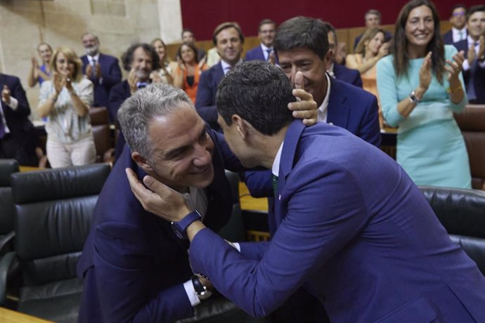 El candidato ya investido, Juanma Moreno, (d) saluda a el consejero de Presidencia en funciones de la Junta de Andalucía y Coordinador de General del PP, Elías Bendodo, (d) durante la segunda jornada del debate de investidura del presidente de la Junta 