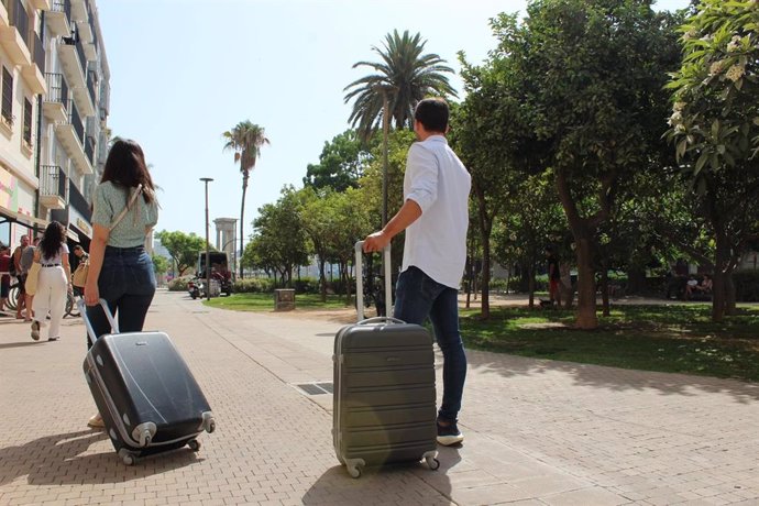 Dos turistas en Málaga capital con sus maletas