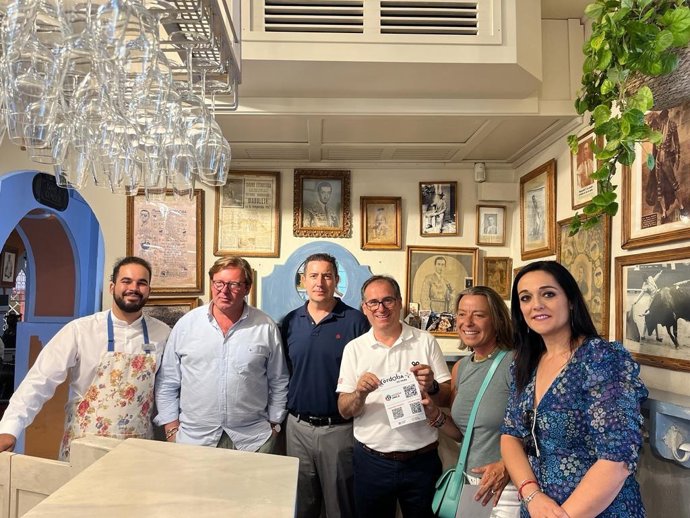 El hostelero cordobés, Miguel Cabezas, muestra los QR de la Agenda Única de Córdoba, entre Fran de la Torre e Isabel Albás.