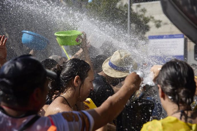 Varias personas disfrutan del agua durante la celebración de la Batalla Naval, uno de los atractivos de las Fiestas Patronales de la Virgen del Carmen en el distrito de Puente de Vallecas, a 17 de julio de 2022, en Madrid (España). 