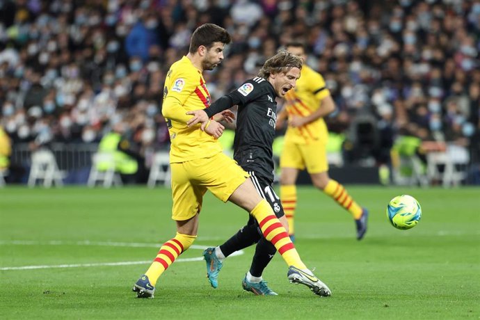 Archivo - El croata del Real Madrid Luka Modric driba al azulgrana Gerard Piqué en un Clásico en el Santiago Bernabéu. 