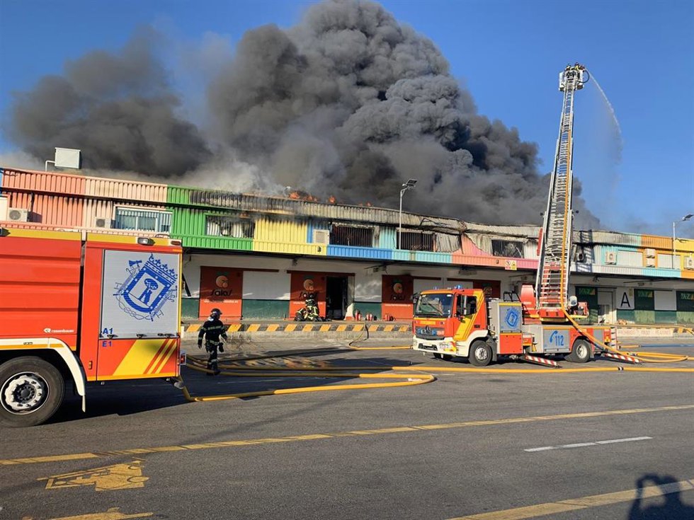 Bomberos del Ayuntamiento de Madrid intentan controlar un incendio en una nave de fruta en Mercamadrid.