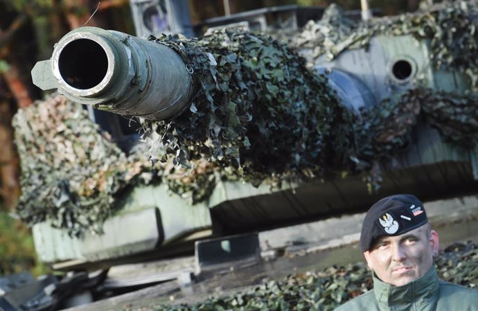 Archivo - Un soldado polaco se para frente a un tanque de batalla principal polaco Leopard 2 en el área de entrenamiento militar de Jaegerbrueck