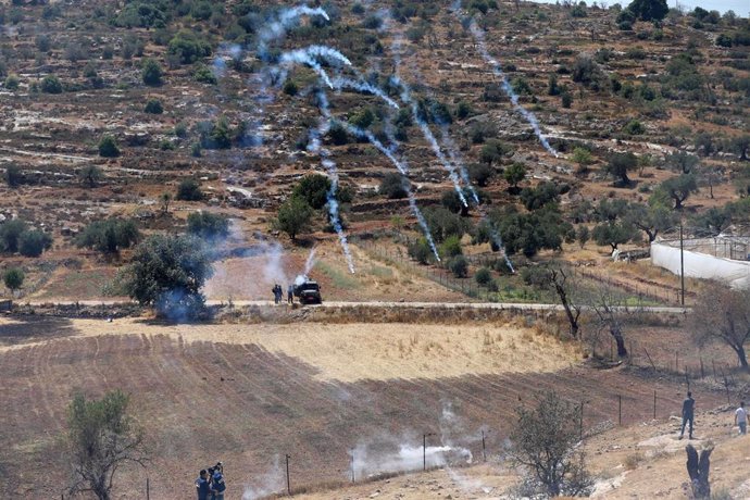 Las fuerzas de seguridad de Israel lanzan gases lacrimógenos durante una protesta de palestinos contra un intento de colonos del asentamiento de Eli de hacerse con el control de una fuente de agua en la localidad cisjordana de Qaryut