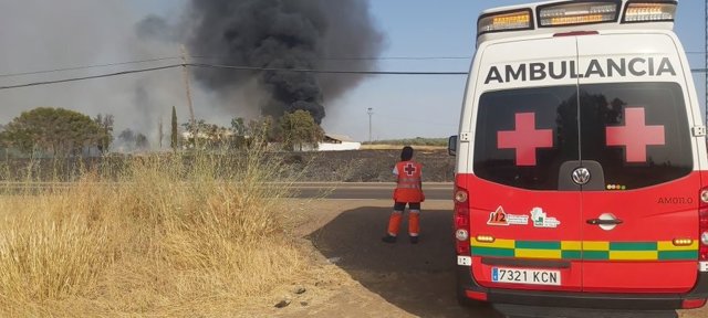 Una ambulancia de Cruz Roja en el incendio declarado en el entorno de la EX-107 de Badajoz a Olivenza.