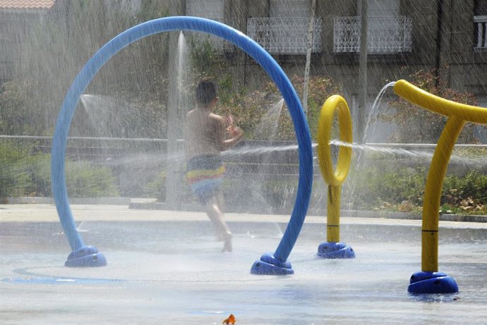 Un niño se refresca en unos chorros de un parque durante un día de la segunda ola de calor de verano en España.