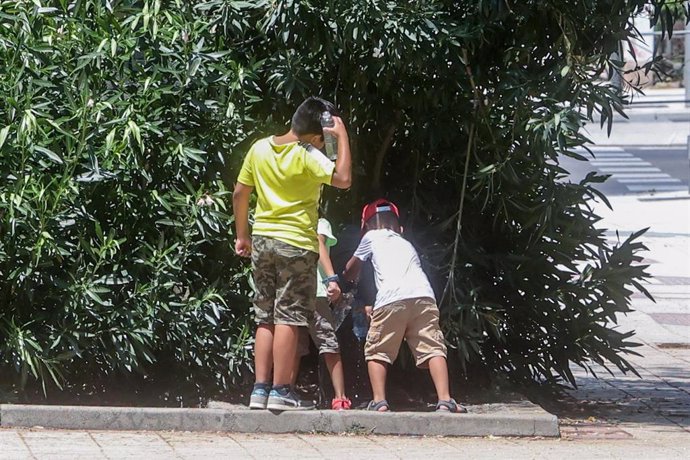 Varios niños rellenan una botella de agua en una fuente, a 12 de julio de 2022, en Madrid (España). La segunda ola de calor del verano podría alcanzar temperaturas máximas de hasta 47 grados centígrados (C) en algunos puntos de la península. En Madrid,