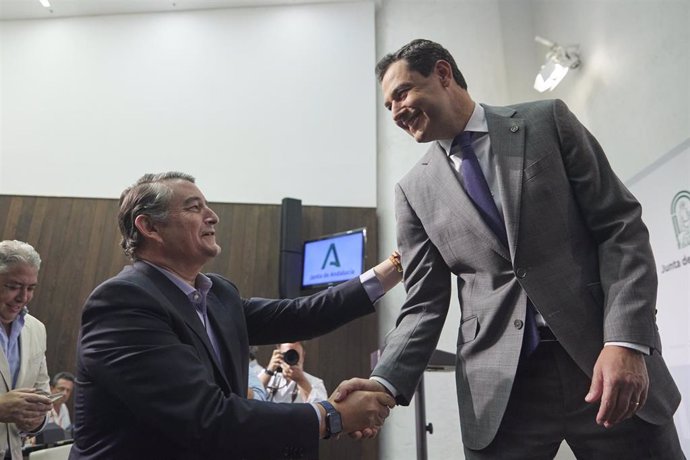 El presidente de la Junta de Andalucía, Juanma Moreno, (d) saluda al nuevo consejero de Presidencia, Antonio Sanz, tras la rueda de prensa para anunciar la conformación del nuevo gobierno en el Palacio de San Telmo, a 25 de julio de 2022 en Sevilla (And