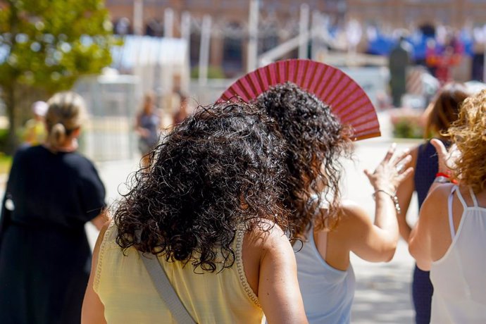 Archivo - Dos mujeres con un abanicos pasean por el Parque de Maria Luisa   en la primera ola de calor con temperaturas que sobrepasaran los 40 grados a 12 de junio del 2022 en Sevilla (Andalucía, España)