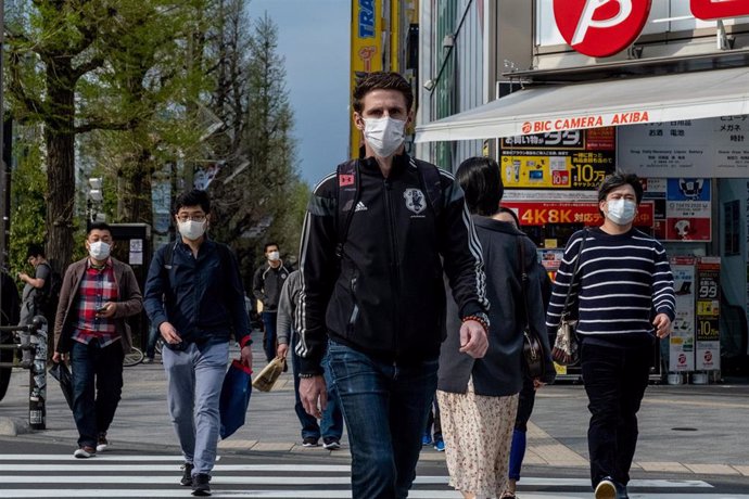 Archivo - 09 de abril de 2020, Japón, Tokio: Se ve a personas con mascarillas mientras caminan por el centro comercial de Akihabara, en Tokio