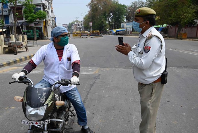 Archivo - Un policía pide a un ciudadano que permanezca en casa en plena pandemia.