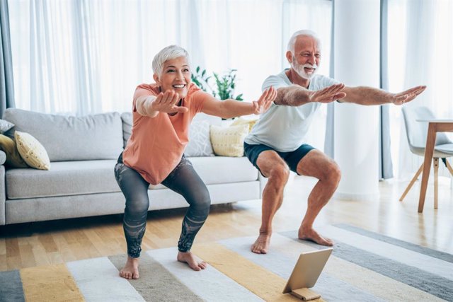 Archivo - Pareja de personas mayors haciendo ejercicio en casa.