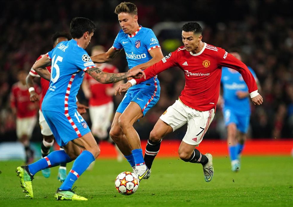 Archivo - Cristiano Ronaldo trata de marcharse de Marcos Llorente y Stefan Savic en el Manchester United-Atlético de Madrid de octavos de la Liga de Campeones 2021-2022