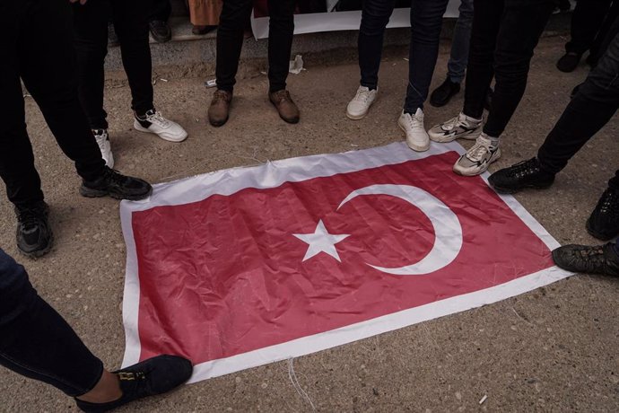 Un grupo de personas pisa una bandera de Turquía durante una protesta por la muerte de nueve turistas en un ataque achacado a Ankara contra un resort en el norte de Irak