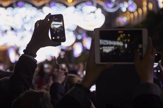 Archivo - Varias personas fotografían luces de Navidad.